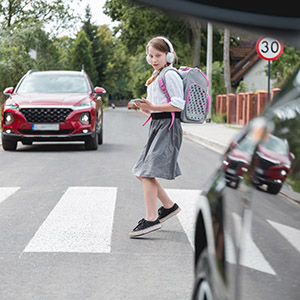 Schoolgirl crossing street in a Florida school zone with a 30 MPH speed limit sign