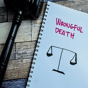 Notebook with WRONGFUL DEATH and scales, next to a gavel, for a Florida claim of Loss of Consortium