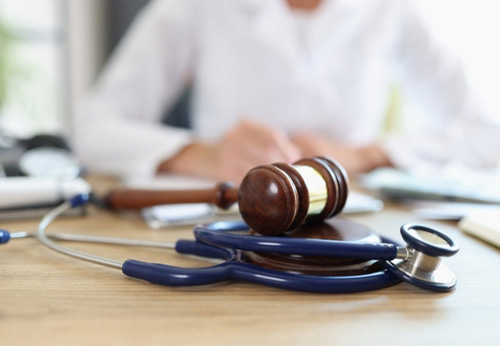 Medical malpractice attorney reviewing case details with a gavel and stethoscope, representing justice