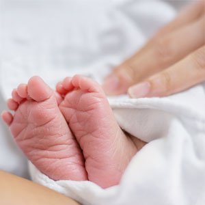 Close-up of newborn baby's feet wrapped in a blanket.