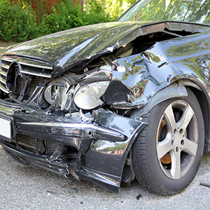 A black car with severe front-end damage, illustrating an accident involving a Rental Car in Florida